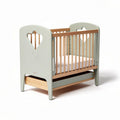 Wooden crib with heart-shaped cutouts in soft green and natural wood finish